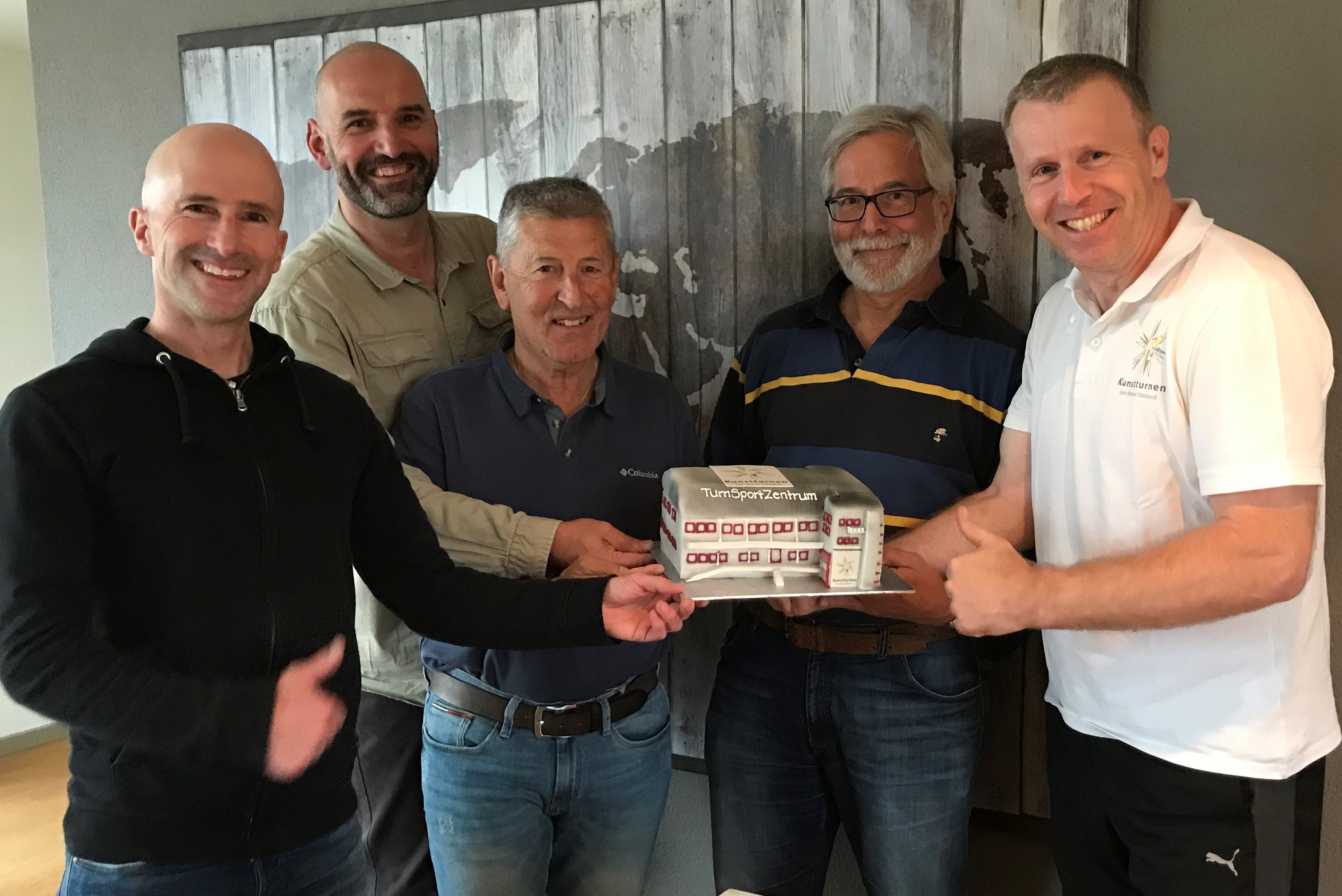 Die 'Arbeitsgruppe Turnsportzentrum Berner Oberland‘ feiert den grossen Erfolg mit einer Immer-Hallen-Torte. (v.l.) Marcel Liniger, Philipp Kunz, Werner Gottier, Sepp Zuppiger, Christoph Läderach